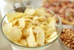 close up of crunchy potato crisps in glass bowl