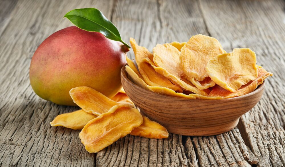 Fresh and dry mango on wooden board