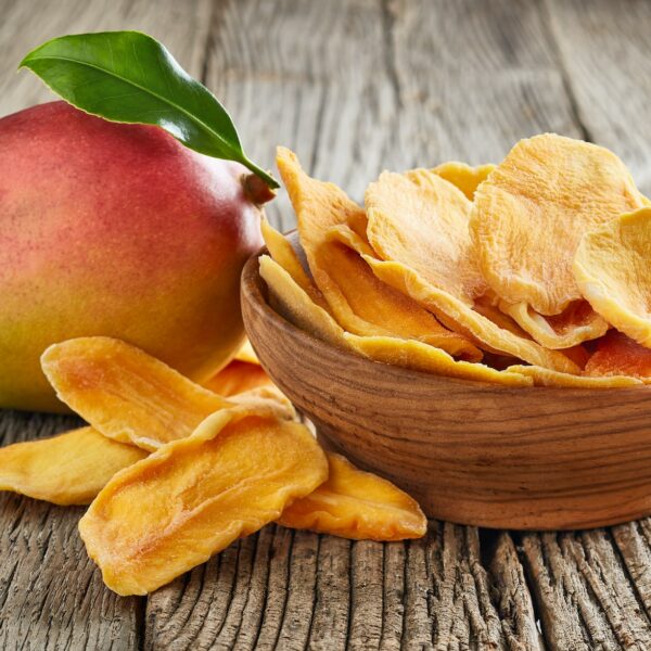 Fresh and dry mango on wooden board