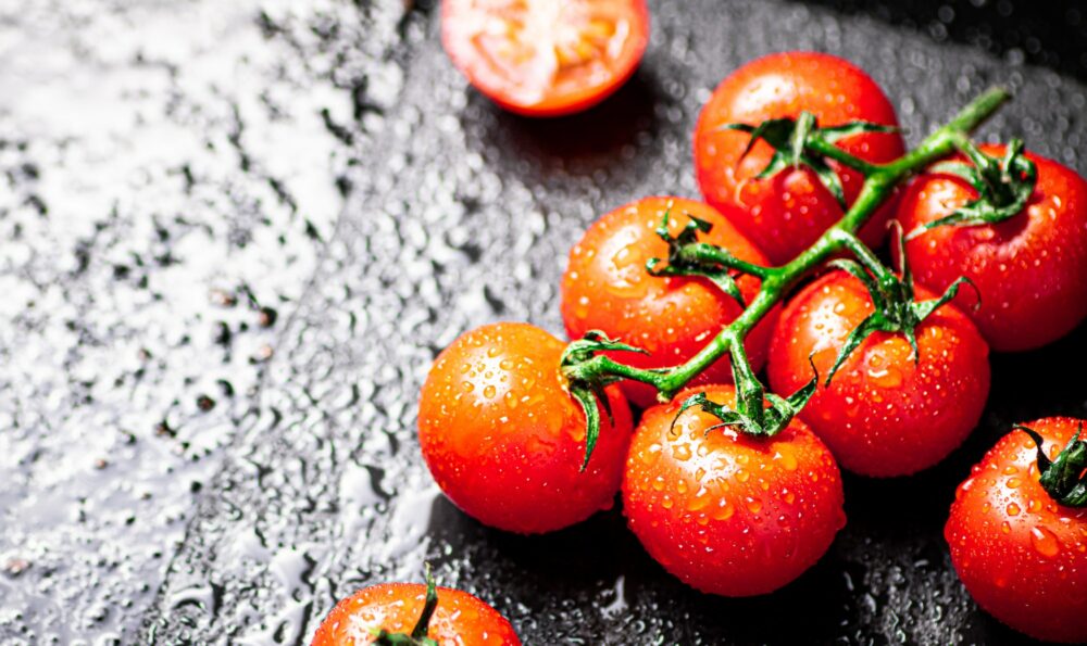 Fresh tomatoes and tomato slices on the table.