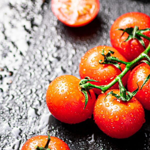 Fresh tomatoes and tomato slices on the table.